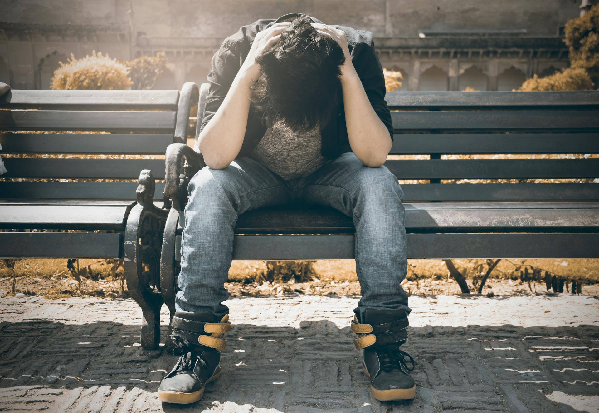 An upset man sitting on a bench | Source: Pexels